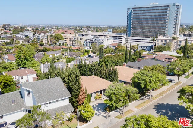 an aerial view of a city with lots of residential buildings ocean and mountain view in back