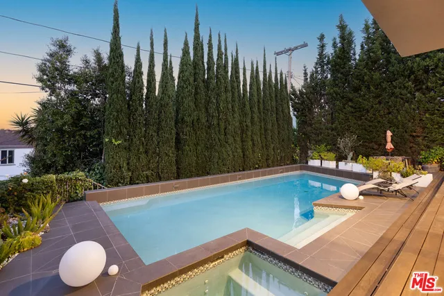 a view of swimming pool with chairs and wooden fence