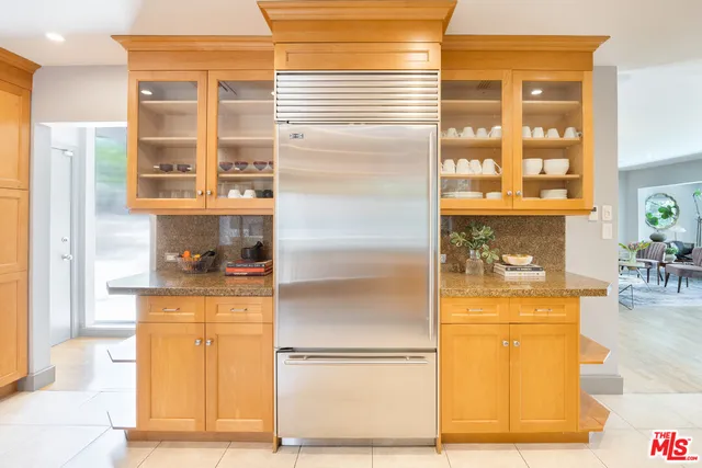 a kitchen with a refrigerator and wooden floor