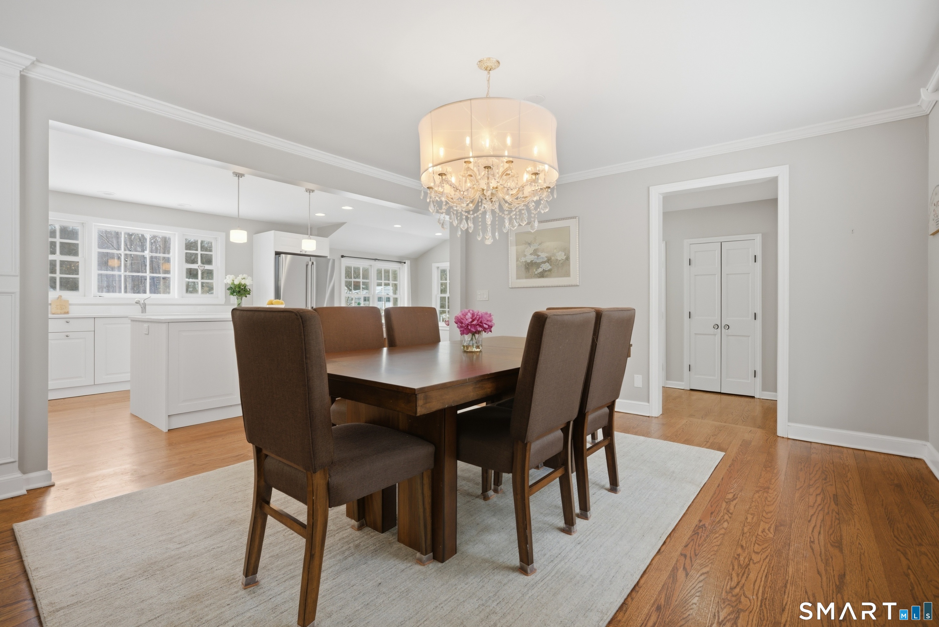 12 Dellwood Road Norwalk, CT 06850 - Photo 4 of 30 a dining room with wooden floor a chandelier a wooden table and chairs