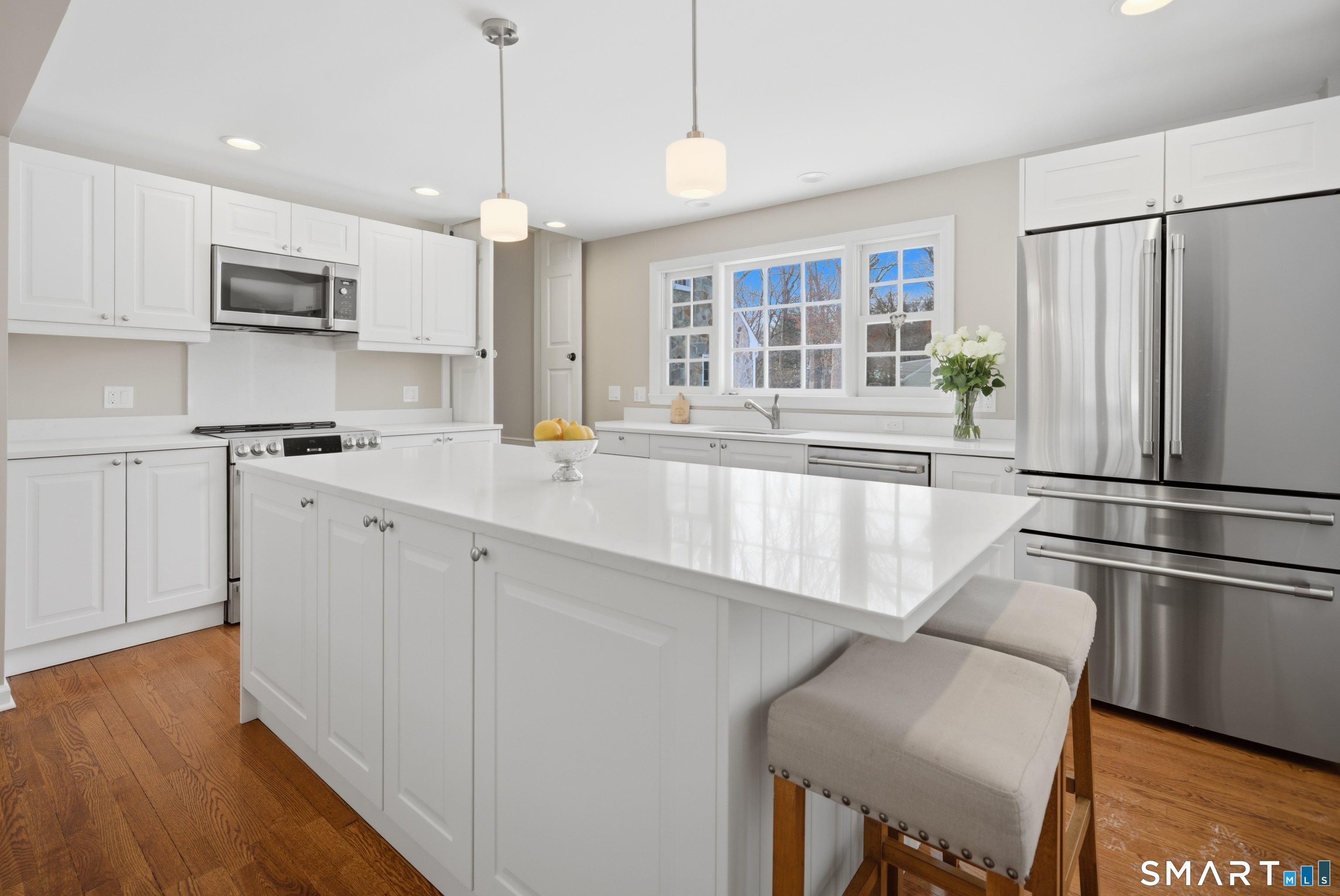 12 Dellwood Road Norwalk, CT 06850 - Photo 6 of 30 a kitchen with kitchen island a counter top space a sink stainless steel appliances and cabinets