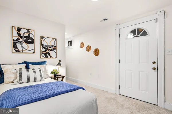 a bedroom with a bed and painting on the wall