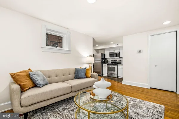 a living room with furniture and a wooden floor
