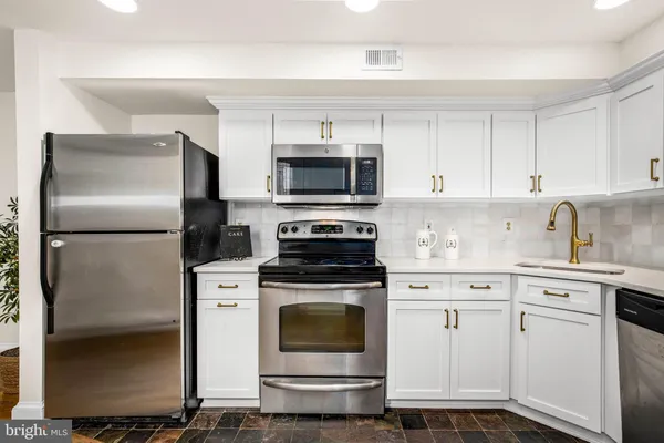 a kitchen with cabinets stainless steel appliances and a sink
