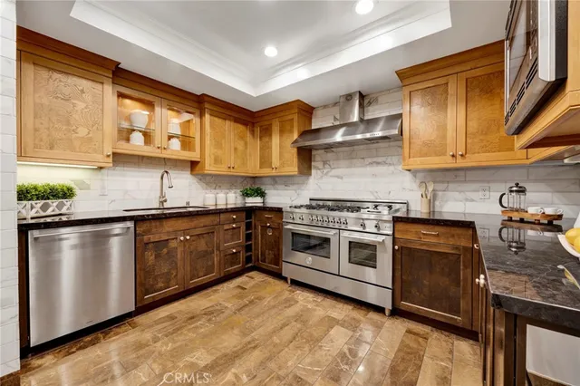 a kitchen with stainless steel appliances granite countertop a stove a sink and a microwave