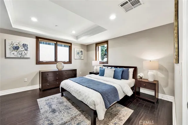 a spacious bedroom with a bed and wooden floor