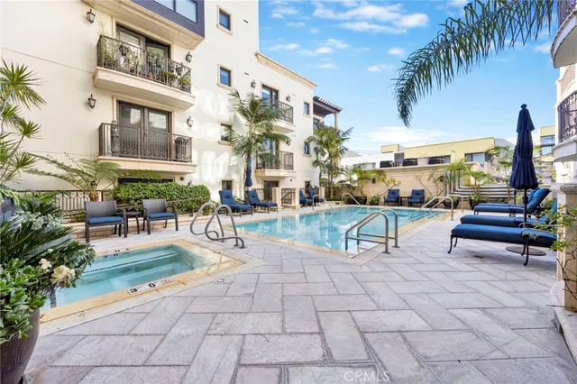 a view of a patio with a dining table and chairs with plants and palm trees