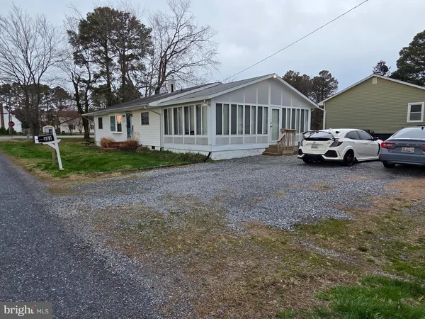 a view of a house with a yard and large trees
