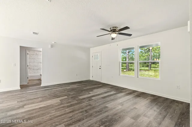a bathroom with a granite countertop bathtub shower sink vanity mirror and toilet