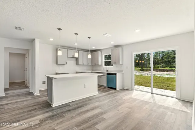 a backyard of a house with plants and large tree