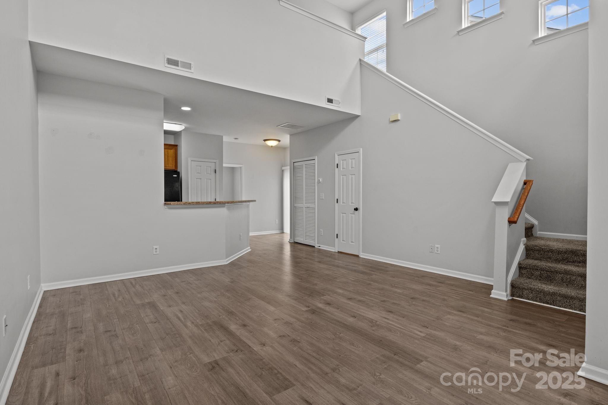 17744 Trolley Crossing Way Cornelius, NC 28031 - Photo 6 of 27 a view of an empty room with wooden floor and stairs