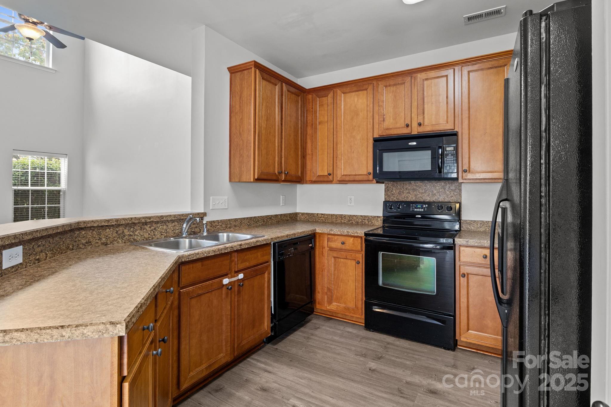 17744 Trolley Crossing Way Cornelius, NC 28031 - Photo 7 of 27 a kitchen with stainless steel appliances granite countertop a stove a sink and a microwave