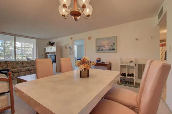 a kitchen with stainless steel appliances granite countertop a table chairs and a refrigerator