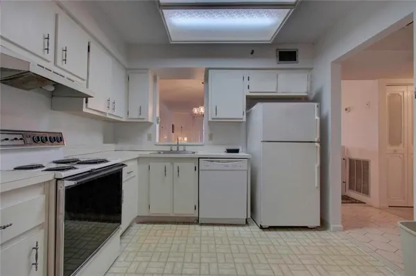 a kitchen with a refrigerator sink stove and cabinets