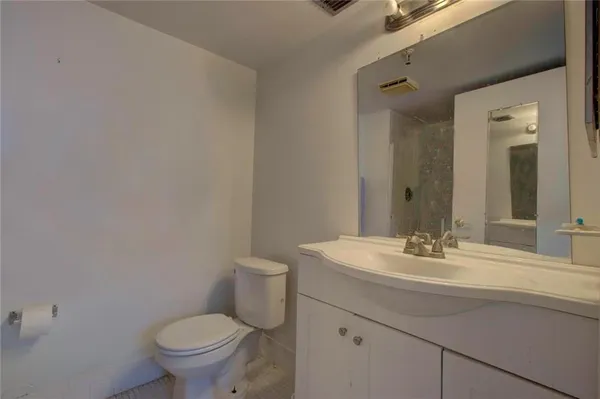 a bathroom with a sink toilet and mirror