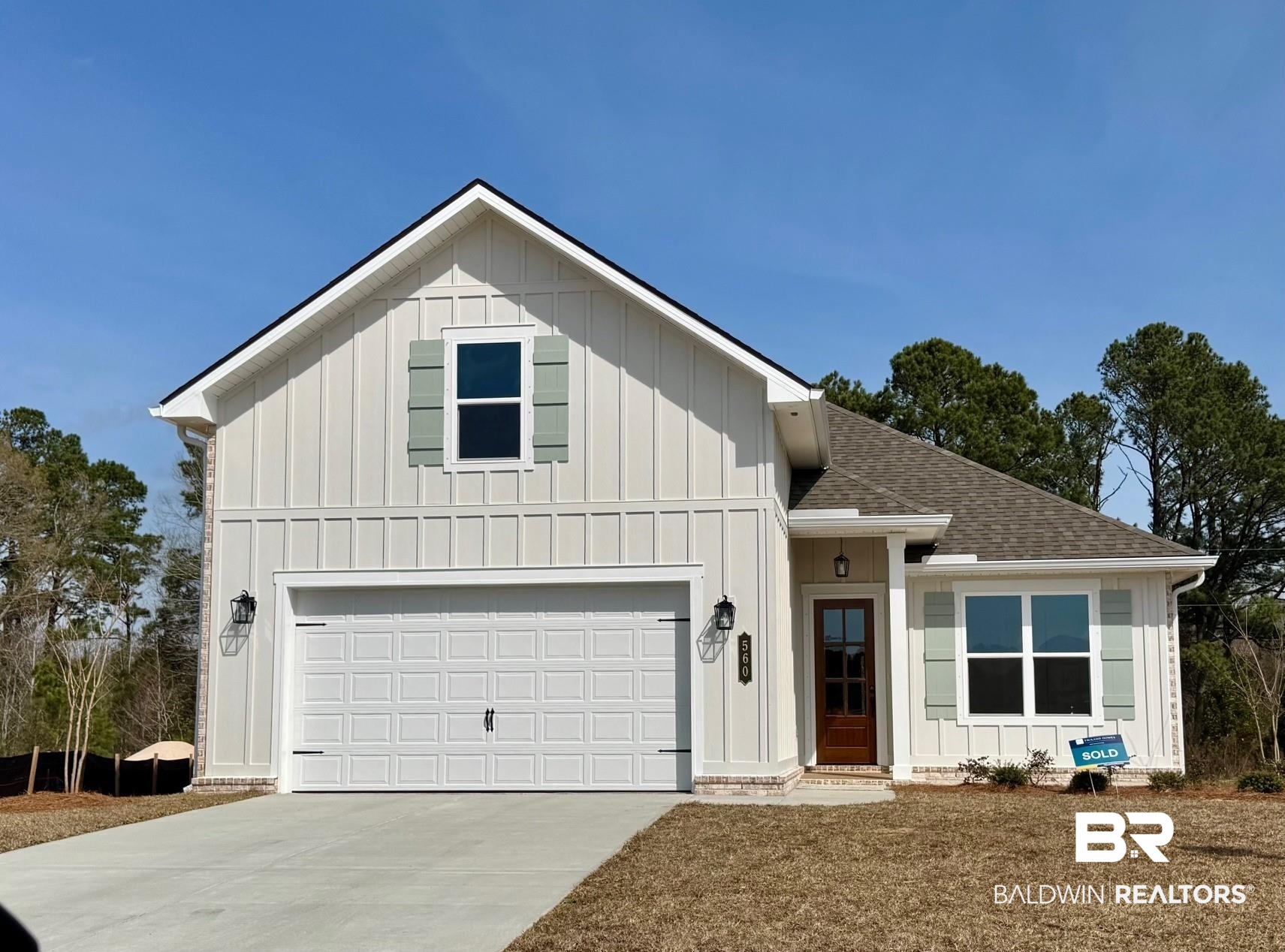 Modern farmhouse style home featuring board and batten siding, roof with shingles, concrete driveway, and a garage