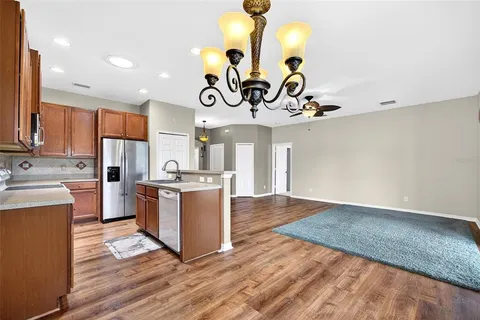 a kitchen with a refrigerator cabinets and wooden floor