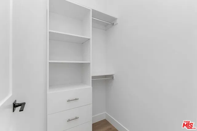 a view of walk in closet with empty racks