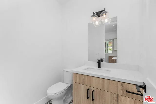 a bathroom with a sink vanity mirror and toilet