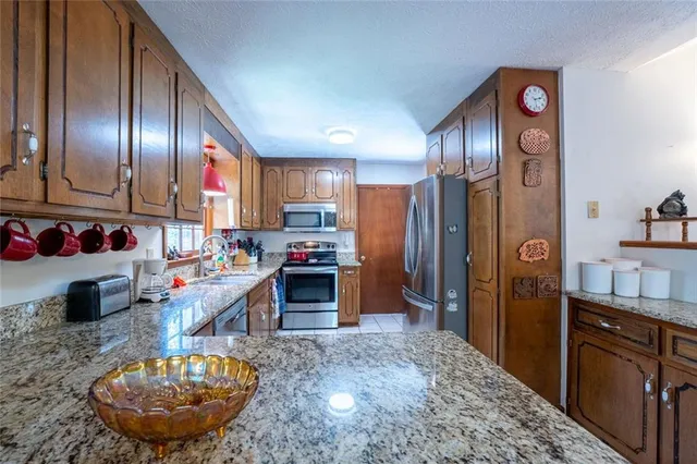 a kitchen with stainless steel appliances granite countertop a refrigerator stove and sink