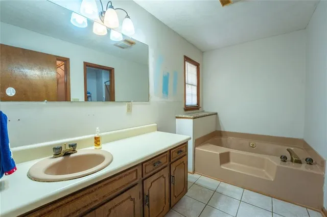 a bathroom with a tub sink and mirror