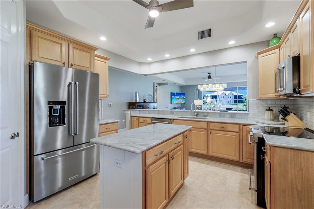 19620 Marino Lake Circle, Unit 2802 Fort Myers, FL 33913 - Photo 19 of 38 Kitchen with a peninsula, appliances with stainless steel finishes, a sink, and light brown cabinets