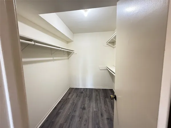 a view of a hallway with wooden floor and a window
