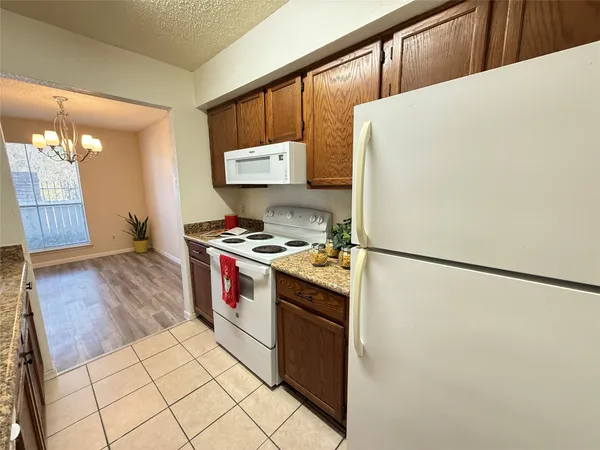 a kitchen with a refrigerator a stove and wooden floor
