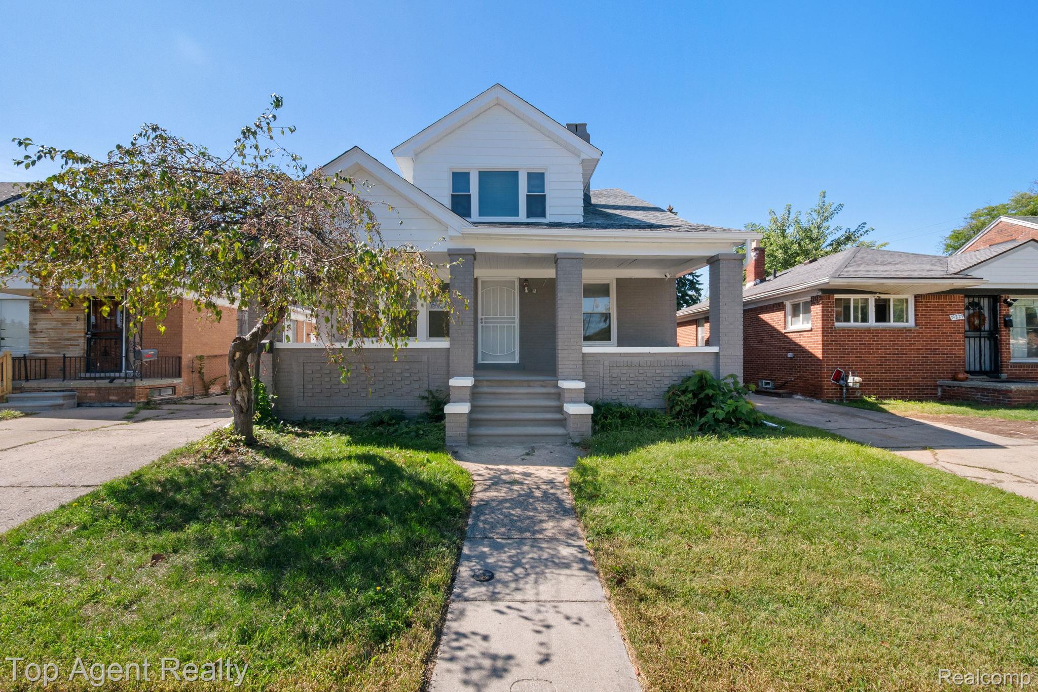 Two-story house featuring an inviting covered porch with pillar supports, a gabled roofline, and a symmetrical facade
