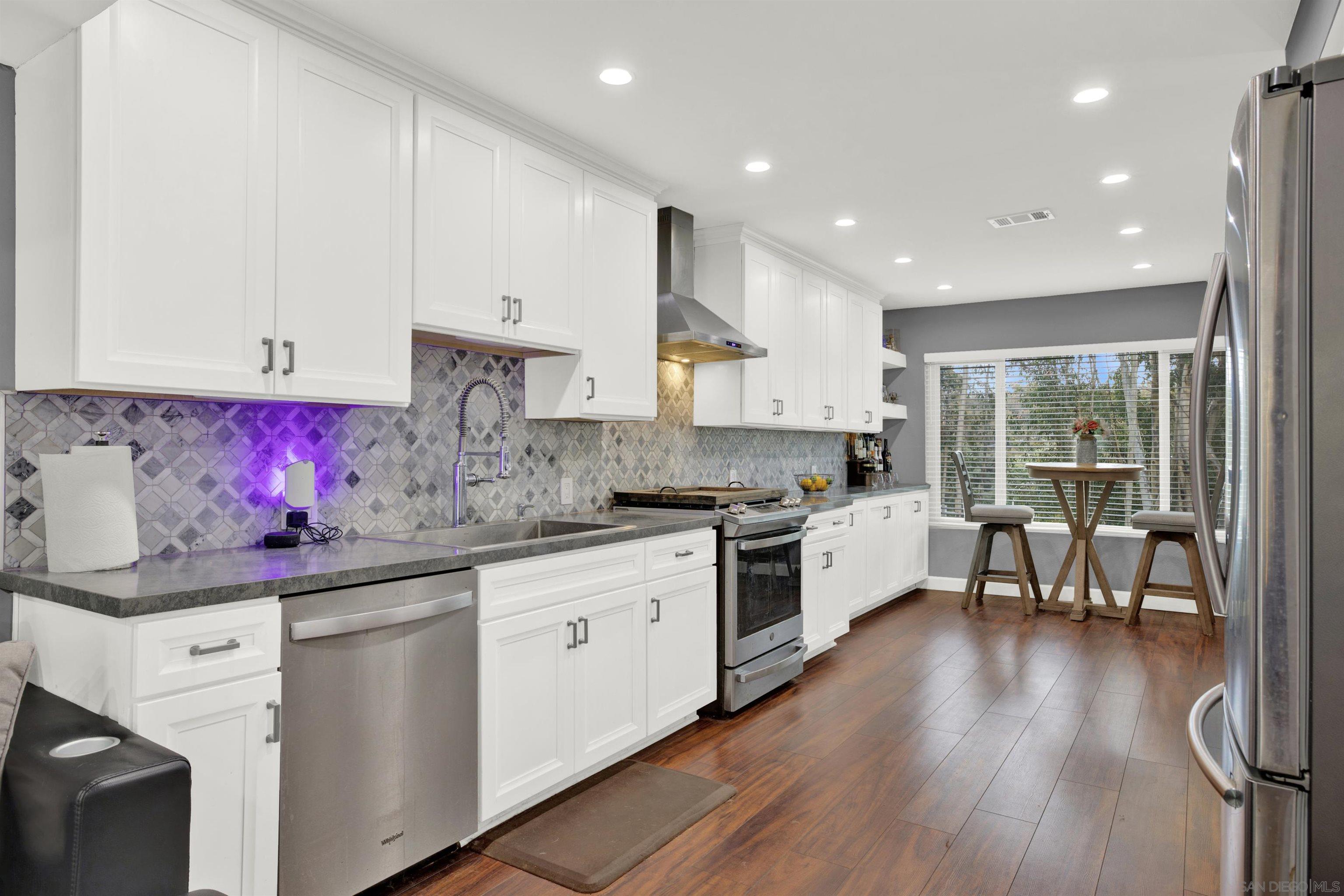 a kitchen with granite countertop white cabinets sink and white appliances