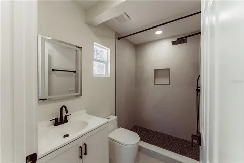 a bathroom with a sink mirror vanity and toilet