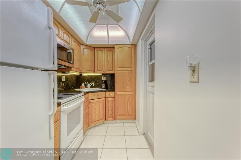 1210 North Riverside Drive, Unit 107 Pompano Beach, FL 33062 - Photo 20 of 29 a kitchen with stainless steel appliances granite countertop a refrigerator a stove and a sink