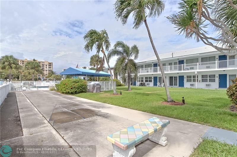 1210 North Riverside Drive, Unit 107 Pompano Beach, FL 33062 - Photo 29 of 29 front view of a house with a yard and palm trees
