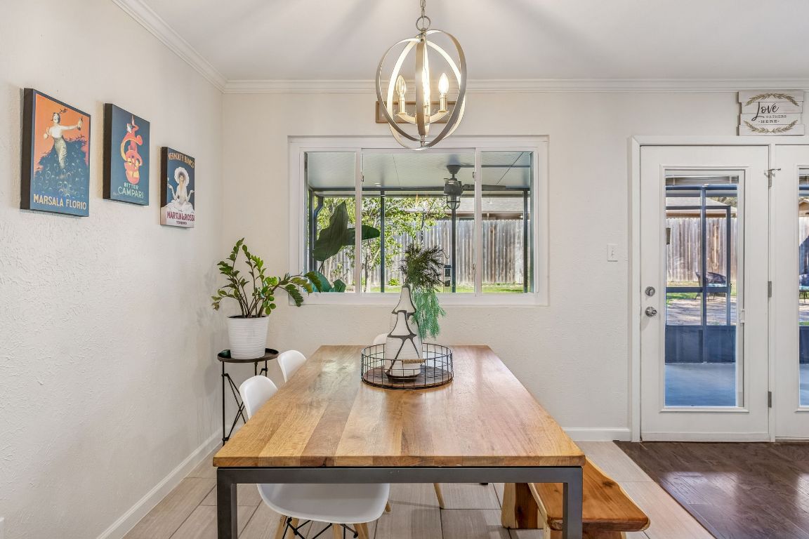 5502 Porsche Lane Austin, TX 78749 - Photo 13 of 32 Dining room with wood finished floors, a chandelier, and crown molding