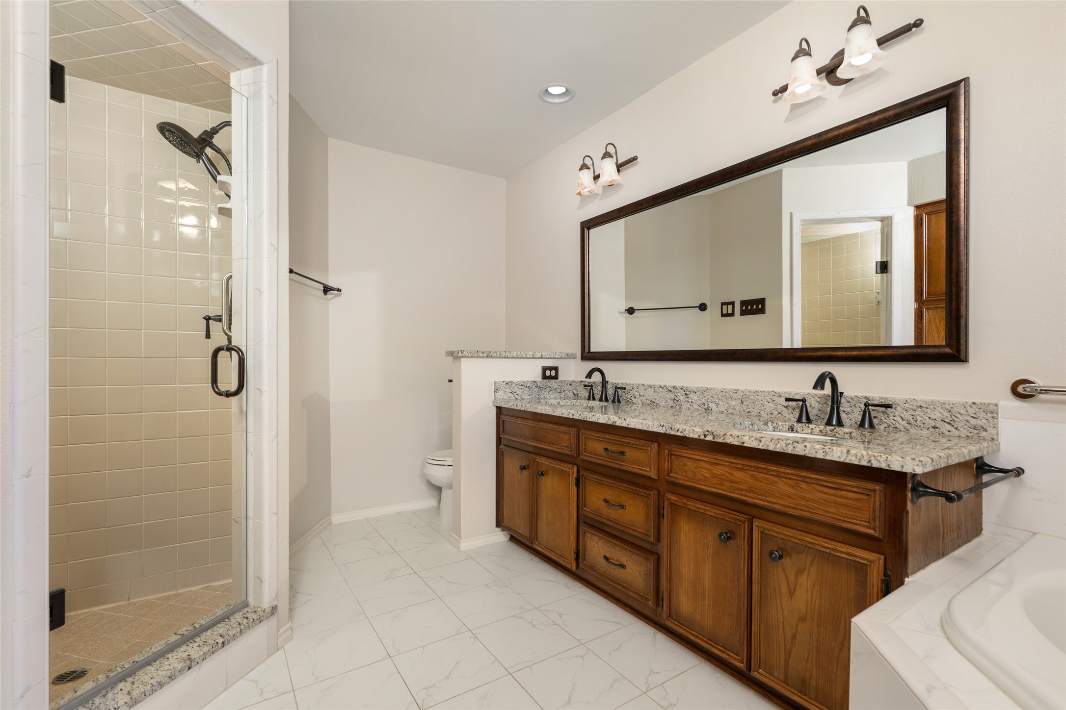 5319 Musket Ridge Austin, TX 78759 - Photo 21 of 39 Double vanity with granite counters and a glass-enclosed shower complement this well-appointed bathroom.