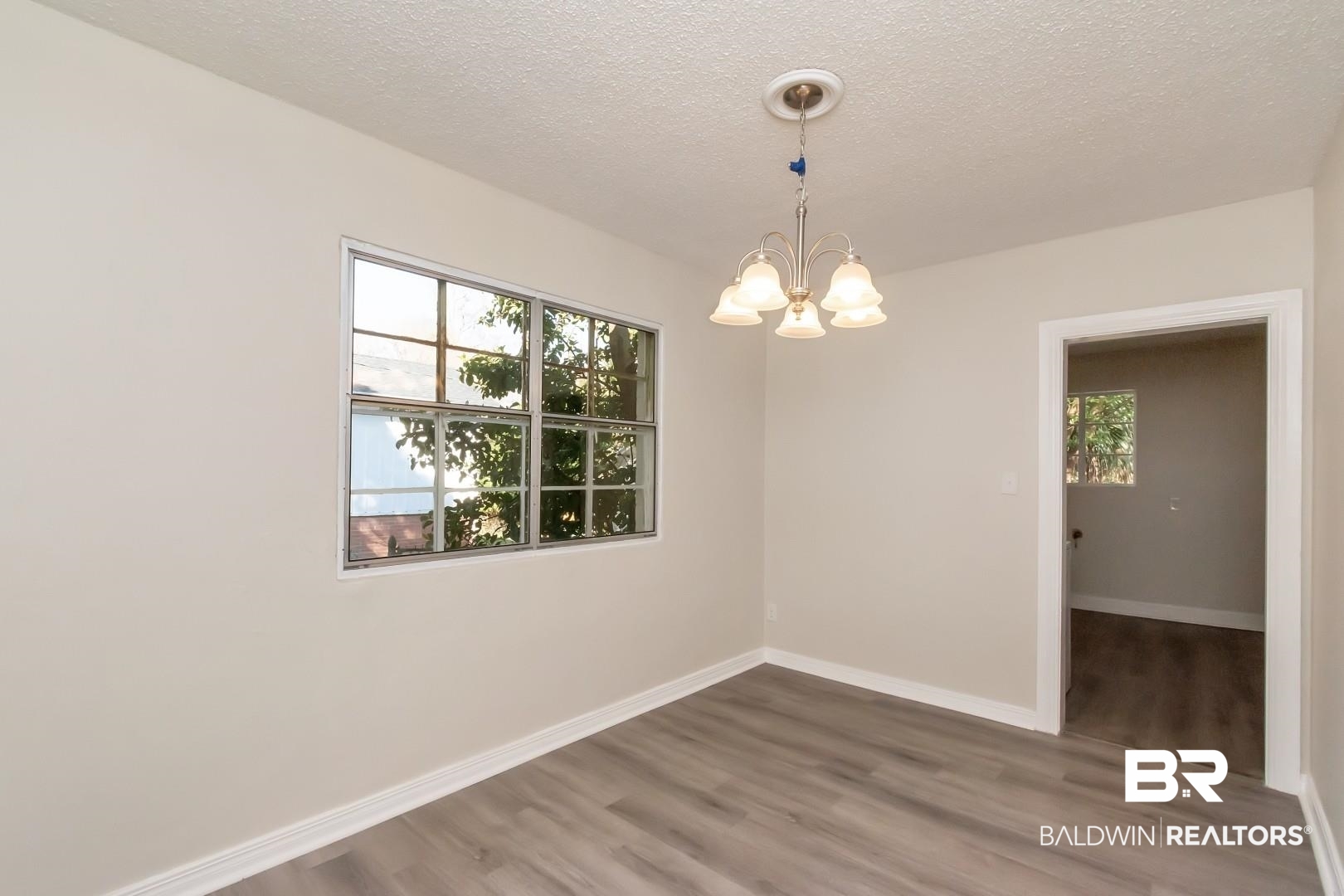 292 Siena Vista Street Mobile, AL 36607 - Photo 11 of 30 Empty room with a textured ceiling, wood finished floors, and baseboards