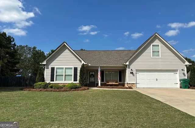a view of a house with a yard and potted plants