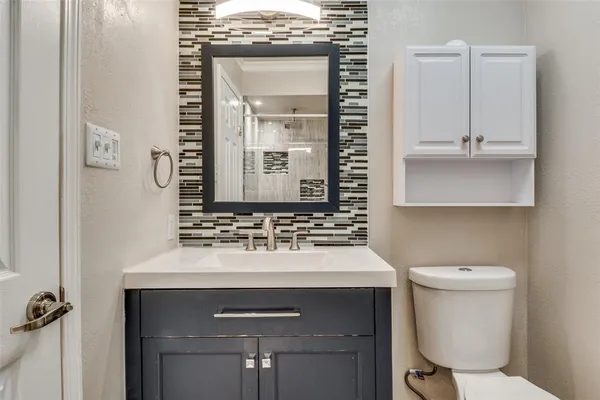 a bathroom with a sink toilet and mirror