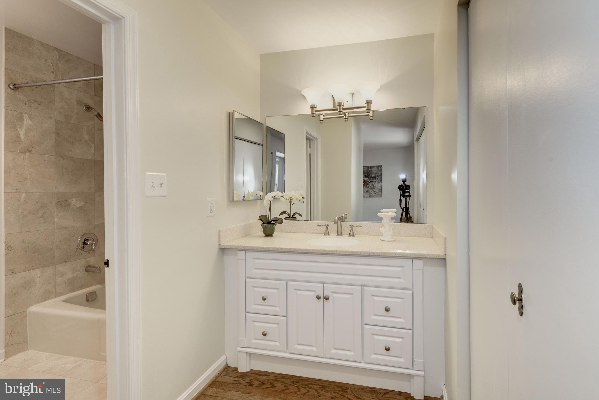 2100 Golf Course Drive Reston, VA 20191 - Photo 14 of 30 a bathroom with a double vanity sink a mirror and a bathtub