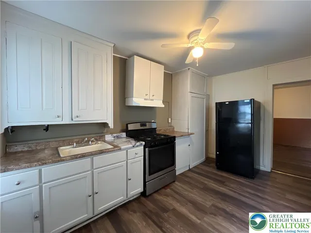 a kitchen with a refrigerator and a stove top oven