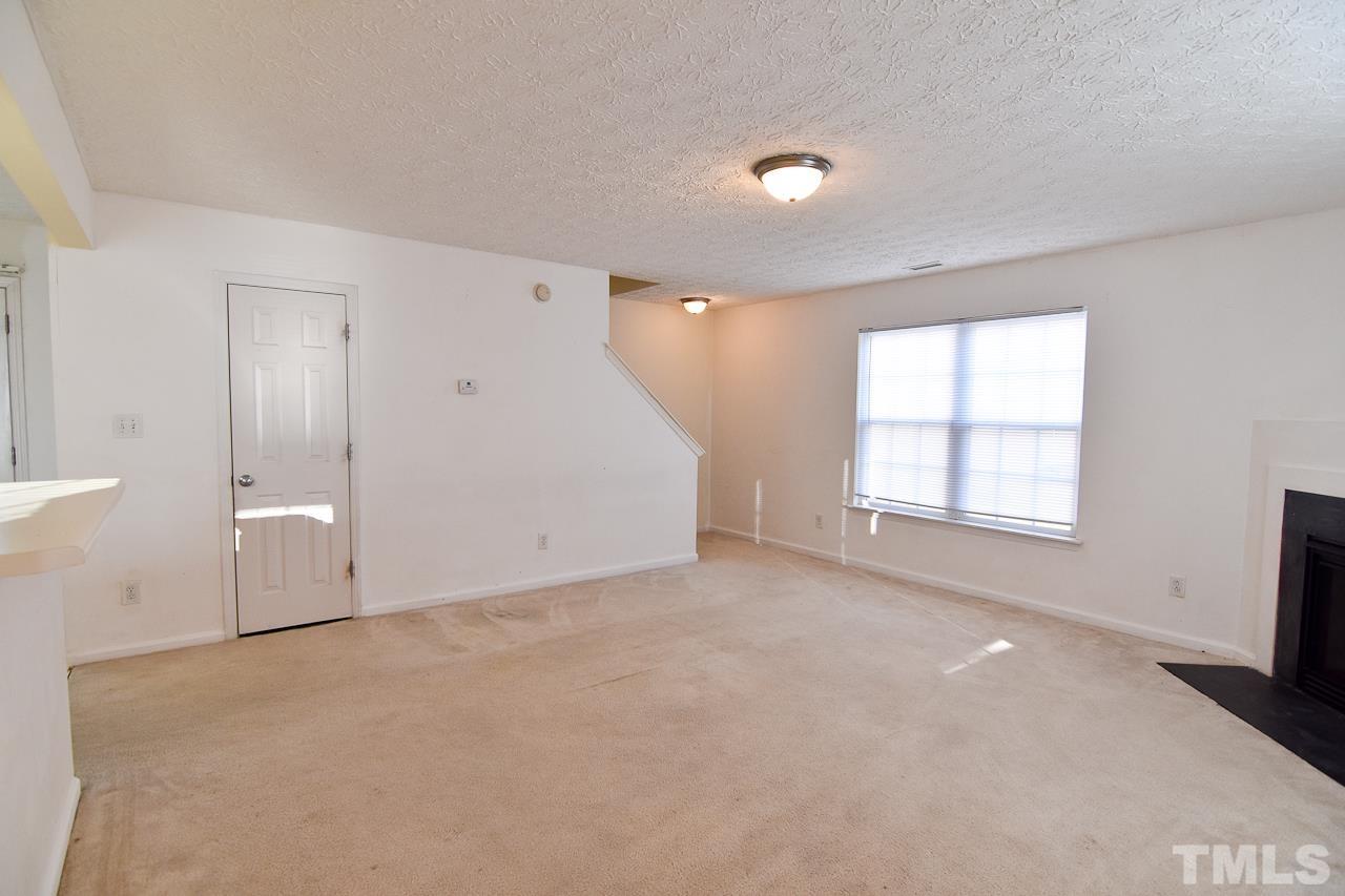 5709 Forest Point Road Raleigh, NC 27610 - Photo 11 of 19 en empty room with windows and fireplace