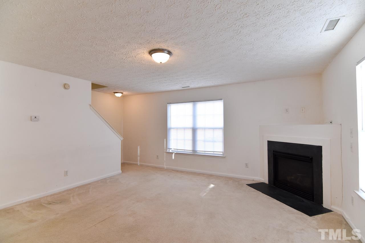 5709 Forest Point Road Raleigh, NC 27610 - Photo 10 of 19 an empty room with windows and fireplace