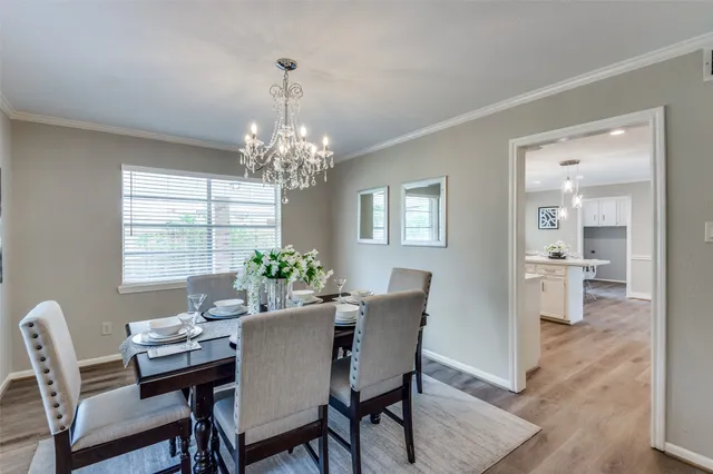 a dining room with furniture a chandelier and wooden floor