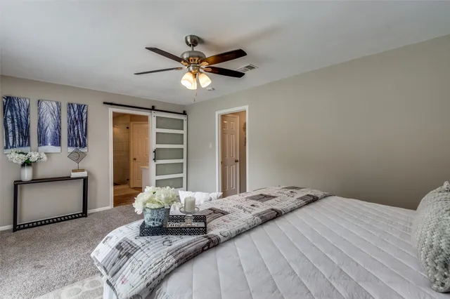 a bedroom with a large bed and ceiling fan