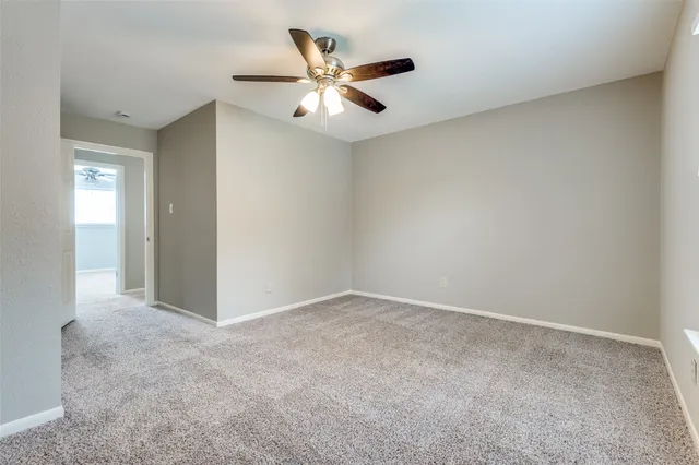 an empty room with closet and ceiling fan