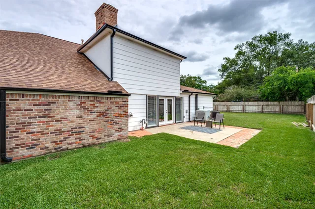 a view of a backyard with table and chairs and wooden fence