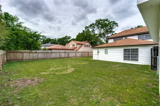 a view of a backyard with table and chairs and wooden fence