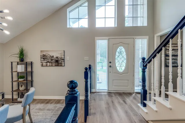 a view of a hallway with wooden floor and entryway
