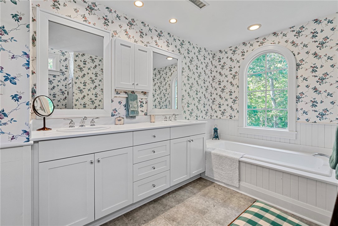 1976 Custis Millpond Road West Point, VA 23181 - Photo 45 of 50 a spacious bathroom with double vanity a mirror a bathtub shower sink and vanity