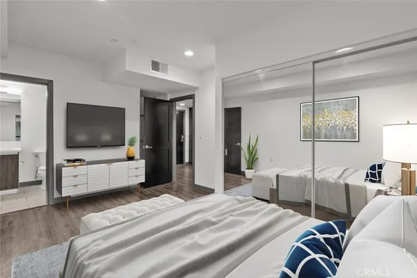 a kitchen with stainless steel appliances granite countertop a refrigerator a sink dishwasher and a oven with wooden floor